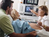 Imagem de um médico que realiza uma ultra-sonografia em uma gestante