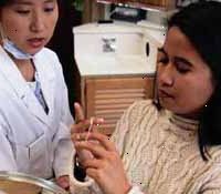 Imagem de uma rapariga que está sendo instruído por seu dentista sobre como usar o fio dental