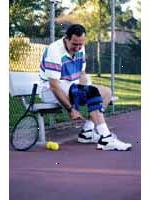 Imagem de um homem vestindo um joelho cinta, jogando tênis