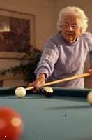 Imagem de uma mulher idosa em uma mesa de bilhar