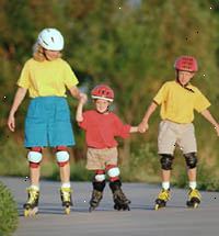 Imagem de uma família, usando capacetes, patins