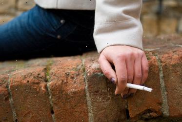 Mulher que prende o cigarro