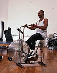 Retrato de um homem exercitar em uma bicicleta ergométrica