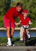 Imagem de um pai que ensina seu filho a andar de bicicleta