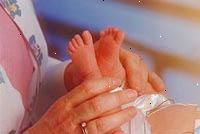 Imagem de uma enfermeira que examinam um recém-nascido