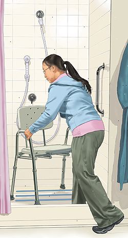 Mulher colocando cadeira de banho em chuveiro. A barra de manobra está na parede. O chuveiro é um bico de água portátil.